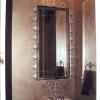 Gothic stlye silver frame around recessed mirror.  Metallic walls and aged silver ceiling in powder room.